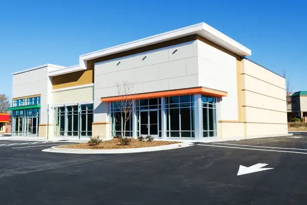 Commercial building with white and beige walls and orange architectural accents by an exterior painter in Greer, SC.
